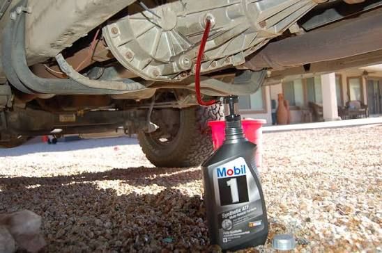 Under-truck view of transfer case and transmission components being serviced to prevent overheating