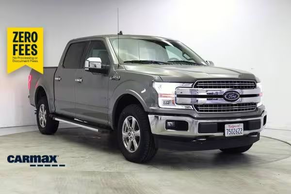 A clean used Ford F-150 parked outdoors with clear and shiny windshield glass