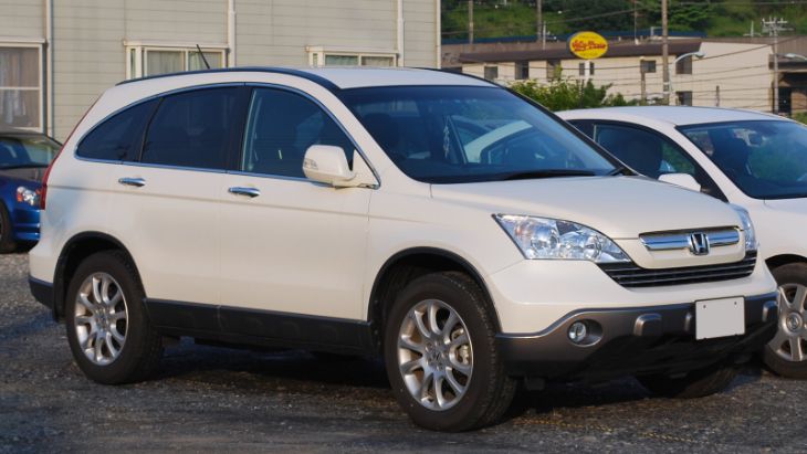 A silver 2009 Honda CR-V parked in a modern residential driveway