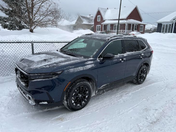 Honda CR-V Hybrid driving safely on a snowy winter mountain road
